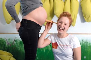 Im Geburtshaus Wuppertal hört eine Hebamme am Bauch einer Schwangeren